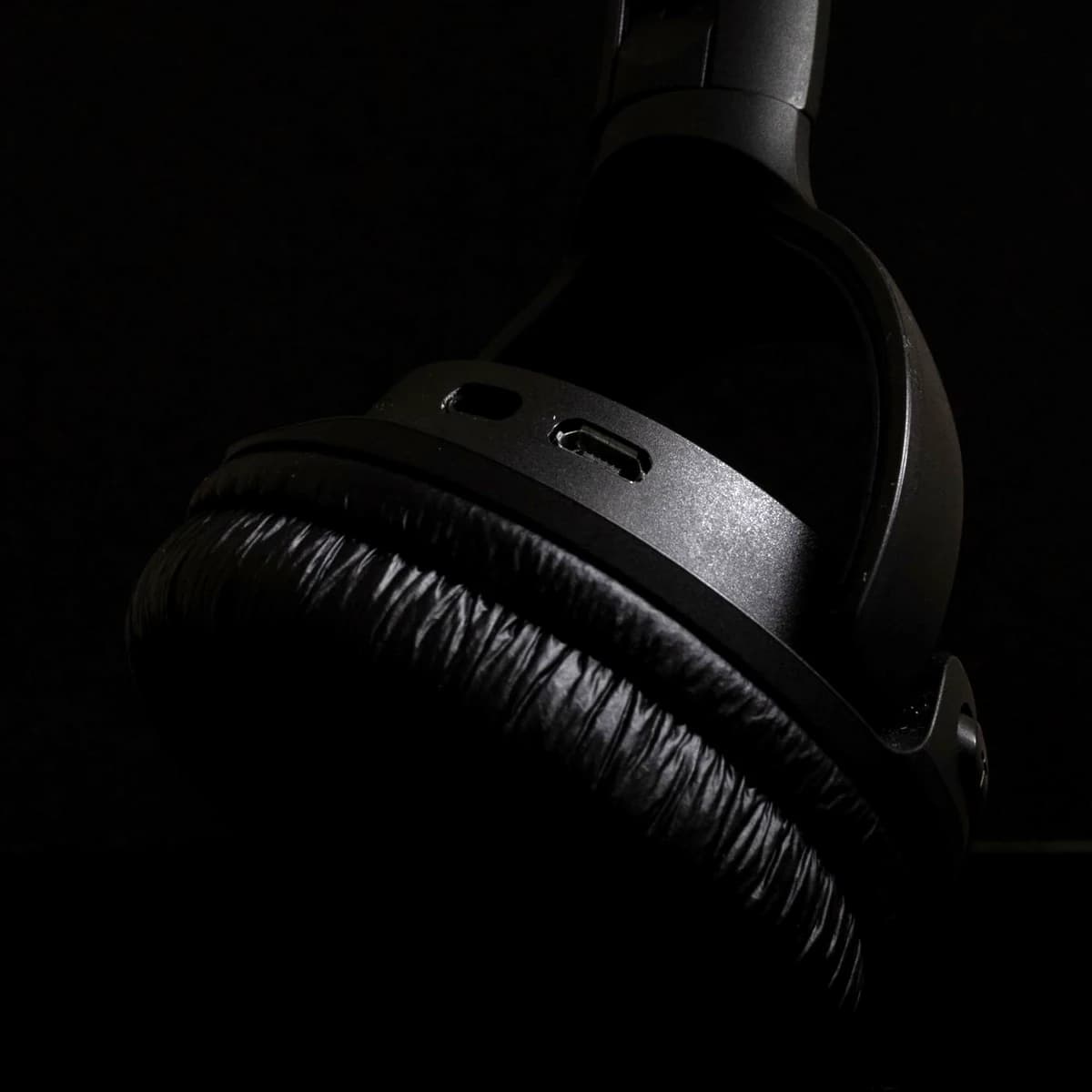 Over-ear headphones photographed close up against a dark ground