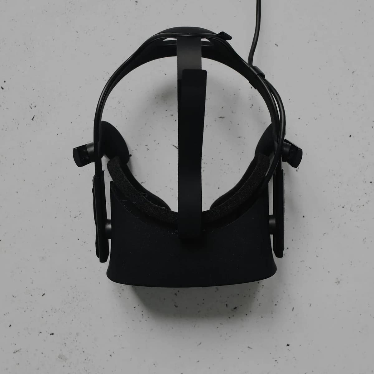 A virtual reality headset resting on a pale concrete surface